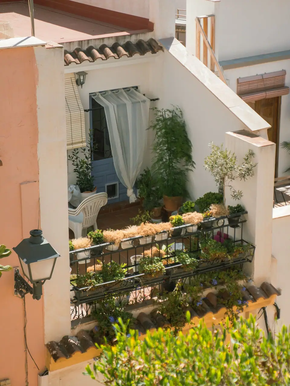 Balcony full of leafy potted plants with a lounge chair