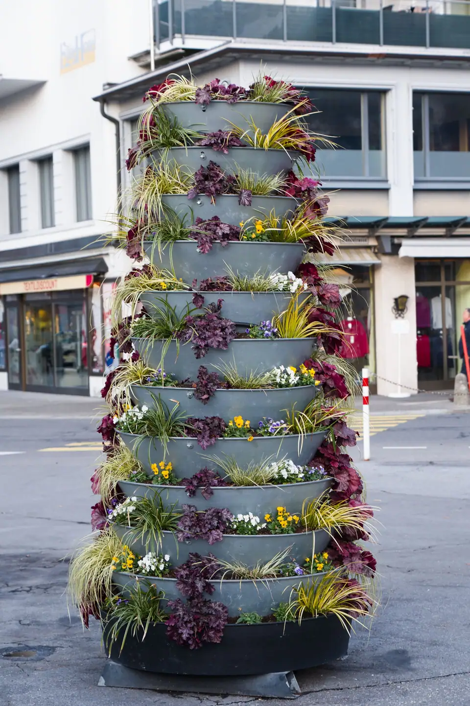 Tall tiered tower planter of flowering plants on a city street